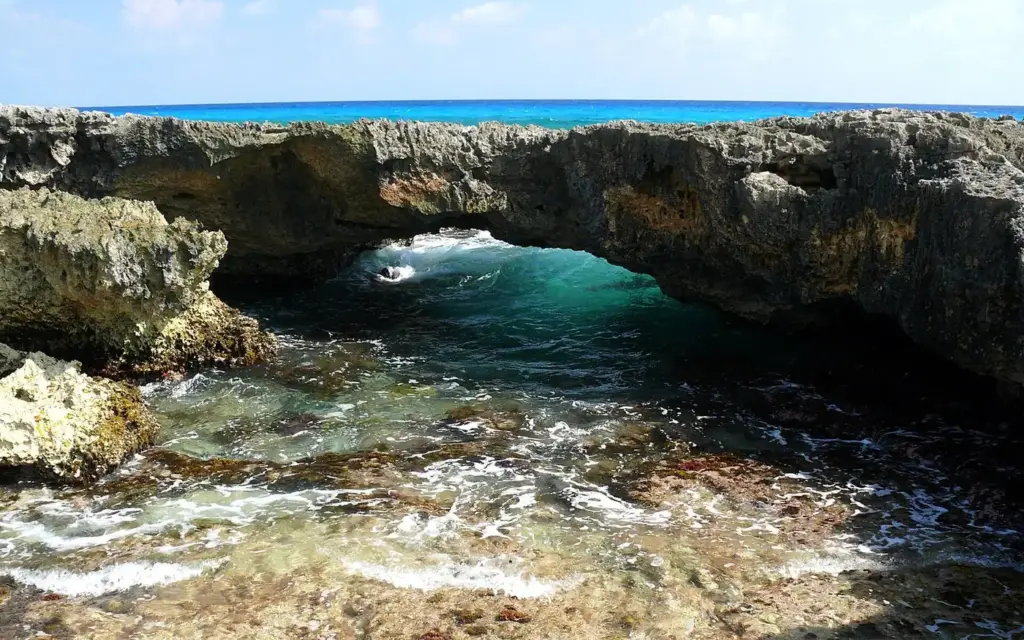 Natural rock arch over surging turquoise water on Cozumel's rugged windward coast