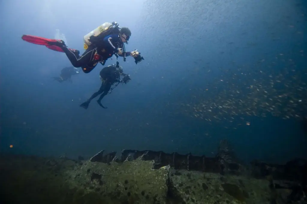 Two divers with cameras photographing the wreck of the German U-boat U-352 off Morehead City, North Carolina