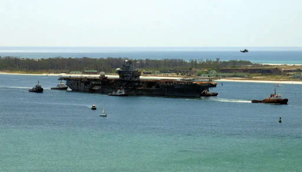 The stripped aircraft carrier Oriskany towed out of Pensacola by tugboats in May 2006 before being sunk as a reef