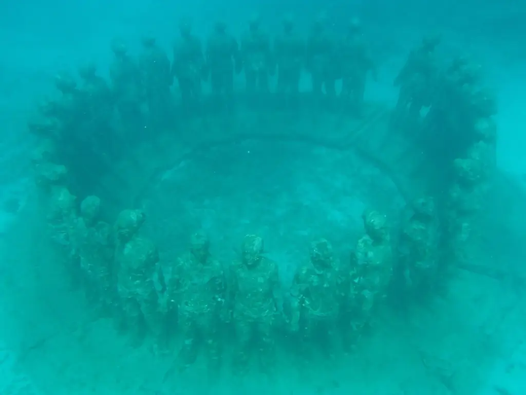 Ring of life-size human sculptures holding hands on the seabed at Grenada's Molinere Bay Underwater Sculpture Park