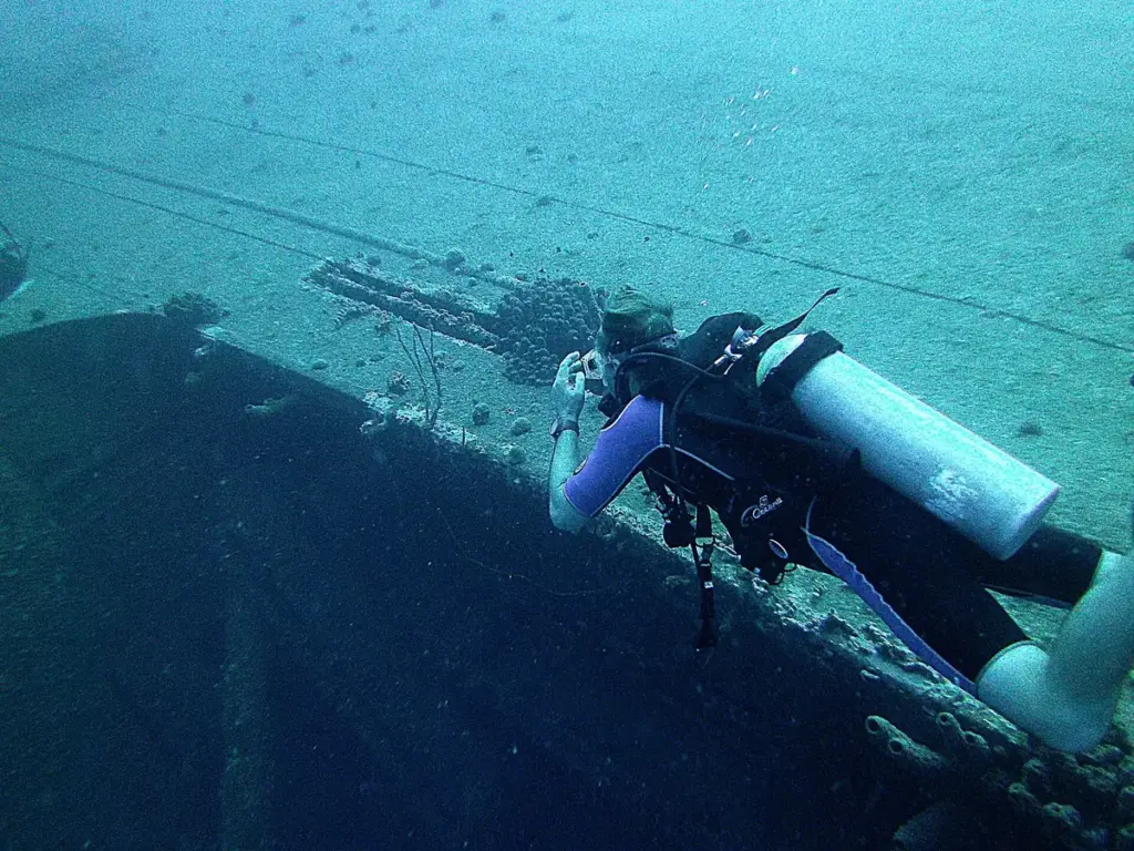 Scuba diver swimming along the upturned port side of the Hilma Hooker wreck off Bonaire