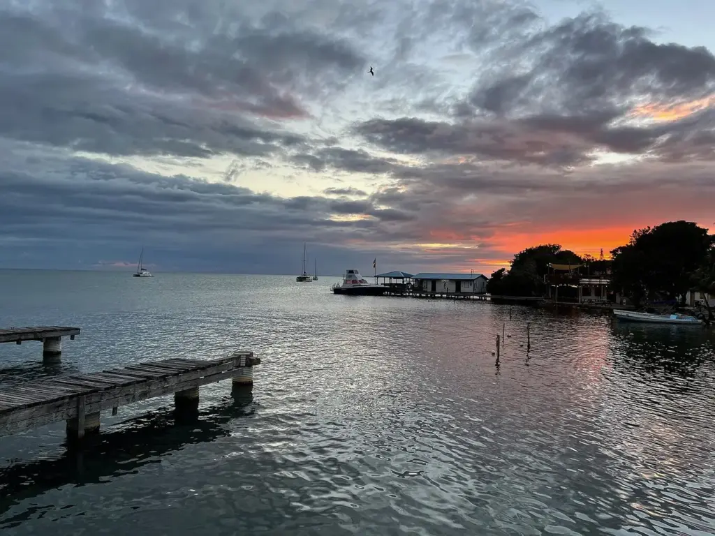 Sunset over the water and wooden piers at Placencia, Belize