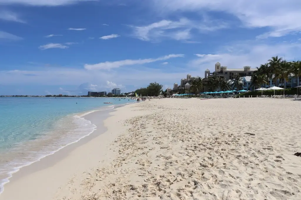Seven Mile Beach in Grand Cayman stretching north, with resorts, palm trees and calm turquoise water