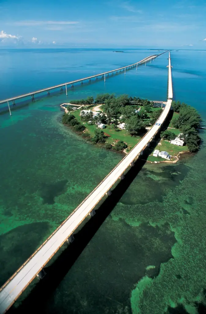 Aerial view of the Seven Mile Bridge crossing Pigeon Key and shallow green water in the Florida Keys