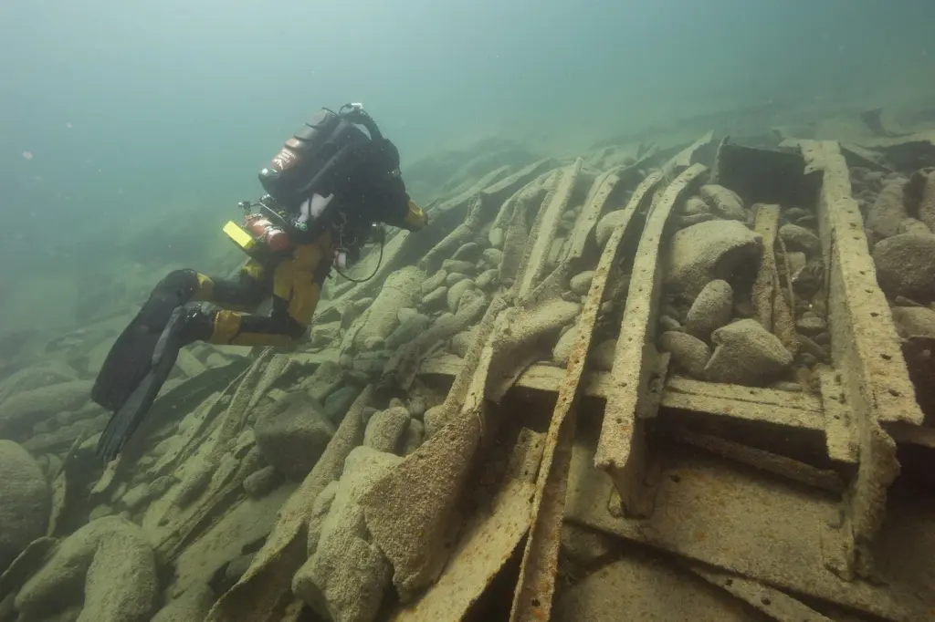 Diver in a drysuit exploring the scattered wreckage of the steamer Algoma in Lake Superior