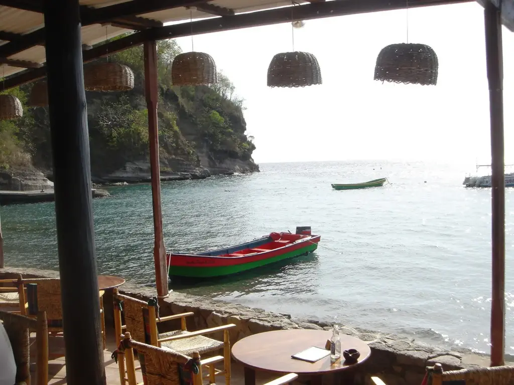 View from a covered seaside terrace over the bay at Anse Chastanet, St. Lucia, with small boats moored offshore