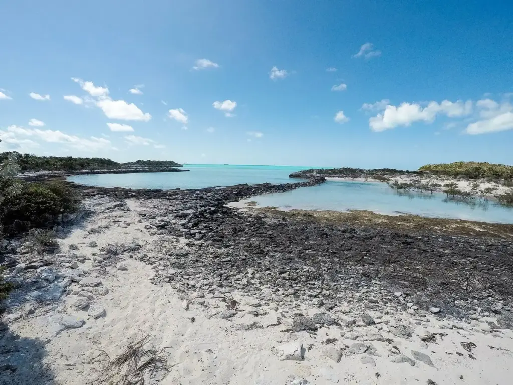 Rocky shoreline and calm turquoise lagoon in the Exuma Cays Land and Sea Park, Bahamas