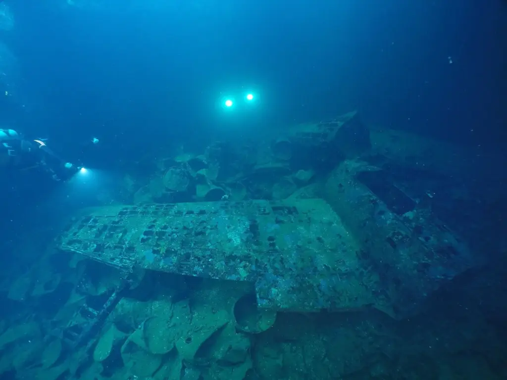 Divers' lights in the cargo hold of the Fujikawa Maru wreck in Truk Lagoon, with wreckage in the foreground
